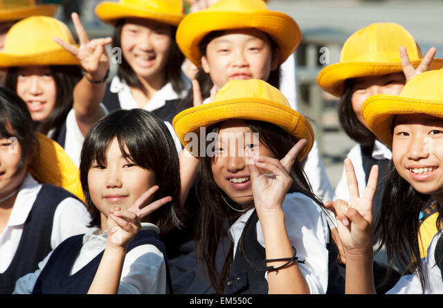 Japan, Kyoto, Group of school girls in their uniforms and yellow hats ...